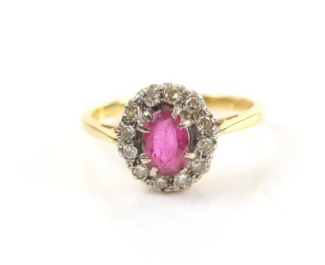 Vintage ruby and diamond set dress ring with oval cut stone 6.6 x 5.6 x 2.3 mm within a border of brilliant cut diamonds, 18 