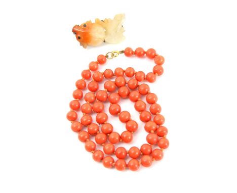 A coral bead necklace, single strand to a bolt ring clasp, length 54 cm, bead size 7 -8 cm and a Chinese carved hardstone fis