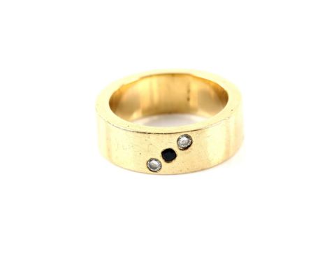 Contemporary gold wedding band set with one round cut sapphire and two round brilliant cut diamonds, testing as 9 ct yellow g