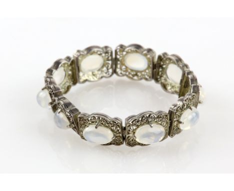 Early 20th C moonstone panel bracelet with ten cabochon stones in filigree decorated mounts, unmarked white metal, length 16 