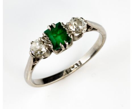 Vintage platinum ring set with two old cut diamonds and a step cut emerald, diamond weight estimated at 0.30 carats, ring siz