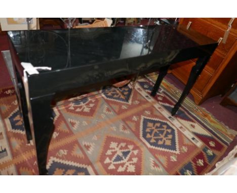 A contemporary black lacquered console table, with shaped supports, H.80cm W.34cm L.130cm 