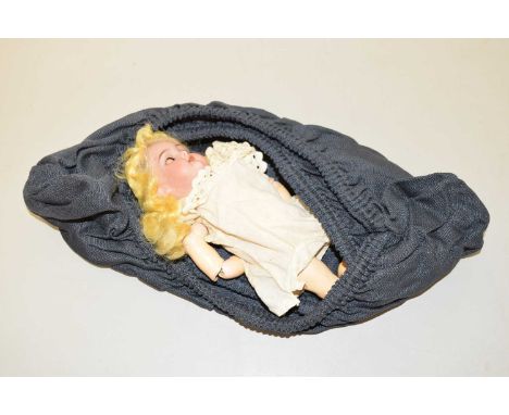 A small porcelain headed doll with composition articulated body