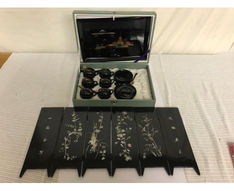 A cased Japanese lacquered tea service; together with a Chinese lacquered and mother-of-pearl inlaid six-door miniature scree