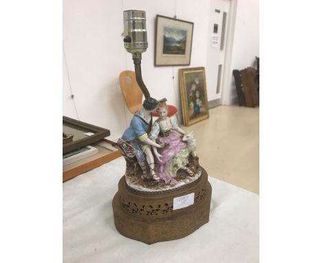 A lamp base figure of two girls and goat