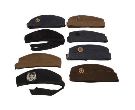 A collection of various military issue side caps, one with Royal Warwickshire Cap badge, another Scottish Rifles, three R.A.F