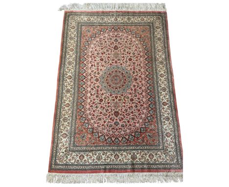 A Persian fine silk rug, signed Islamic calligraphy cartouche, the pink field with a central lobed medallion, with scrolling 
