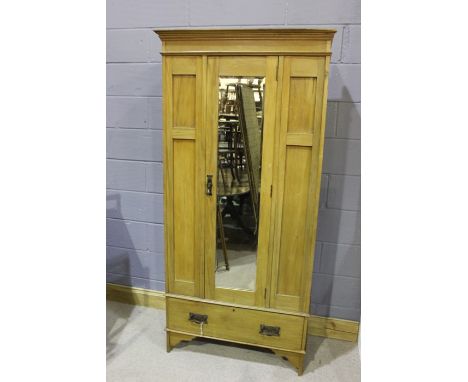 20th Century Art Nouveau style pine wardrobe, the cornice moulded cornice above the mirrored door, opening to reveal a hangin