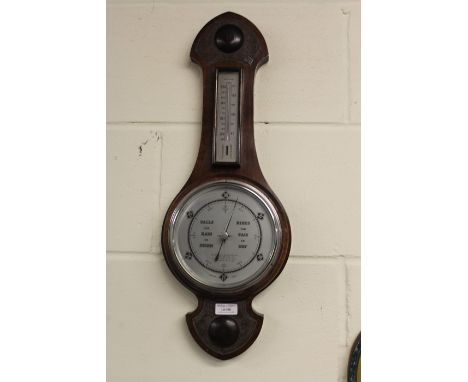 Barometer/ thermometer, housed in a carved oak case