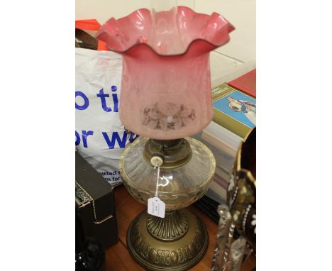 Victorian oil lamp by Benetfink, the ruby frosted glass shade with etched foliate decoration above a glass reservoir and bras