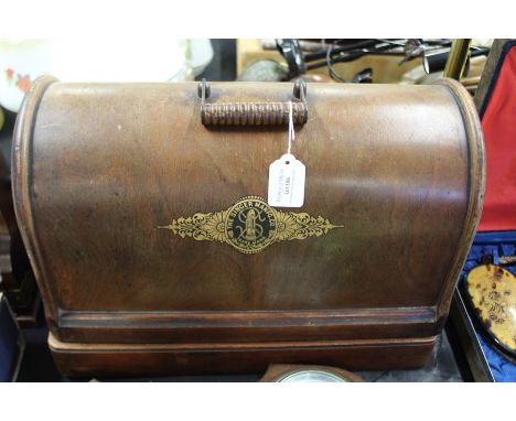 Singer sewing machine, housed in a domed case, barometer/ thermometer in a carved oak case (2)