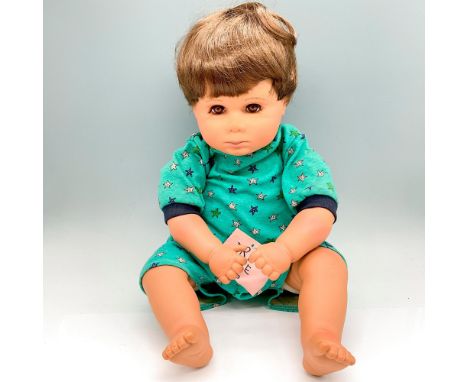 Life sized vinyl doll with brown hair and brown penetrating eyes, dressed in pajamas with a pouty look. Pat Secrist impressed