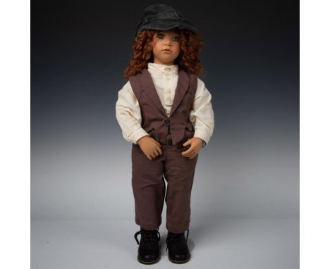Tall resin doll with lifelike features and expression. Charly has curly light brown hair, wears a cream shirt, brown pants an