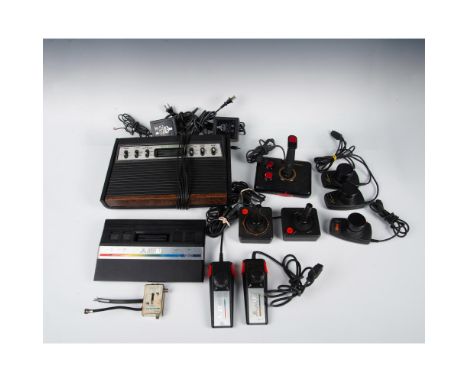 A vintage gaming consoles with several controllers. 2 consoles; the 1977 to 1971 Sears Video Arcade and the 1984 to 1992 Atar