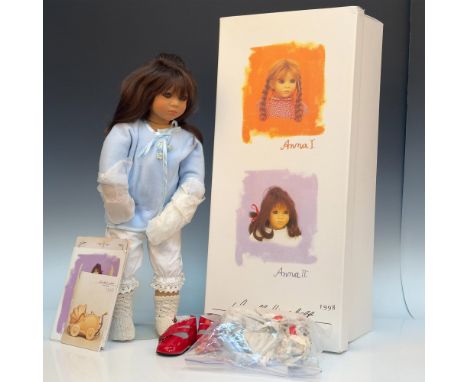 Doll has been created to emulate a 5-year-old with dark brown human hair, violet eyes wearing a white cotton dress and red la