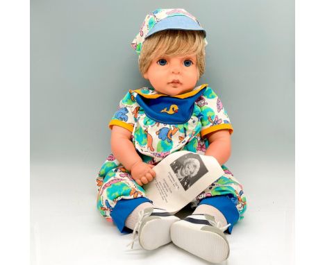 Adorable life-sized vinyl doll is created with blonde hair, blue eyes, wearing Save the Earth printed jumper with matching ha