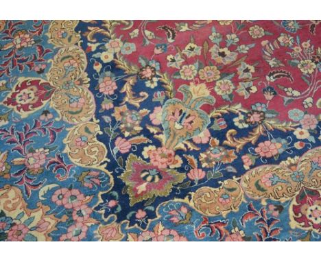 Kirman carpet, central medallion on a patterned floral magenta ground, floral border, 374 x 228cms.