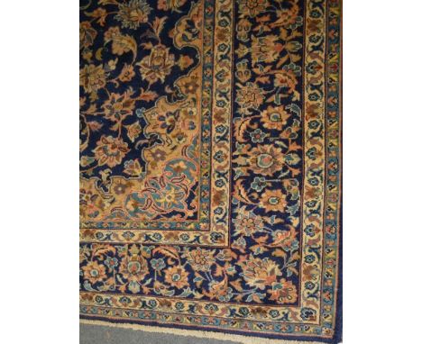 Kashan carpet, central medallion, on a flower filled blue ground, the border within guards, 340 x 212cms.