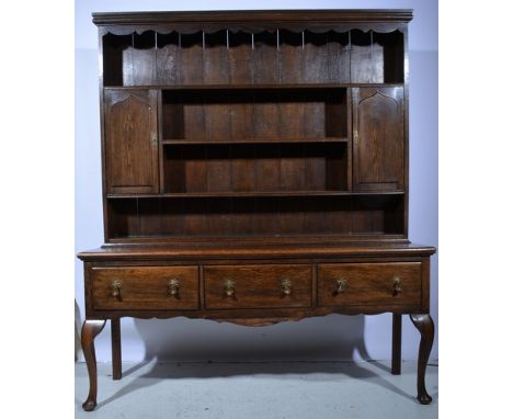 Oak dresser, three shelf delft rack with two cupboards, the base with three frieze drawers on cabriole legs, length 183cm, he