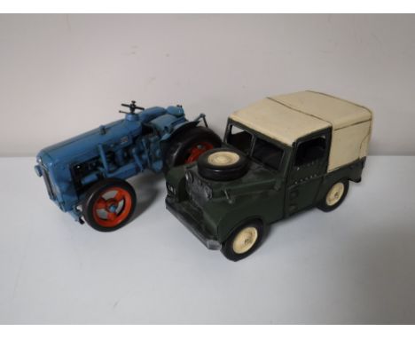 A contemporary metal Fordson tractor together with a land rover