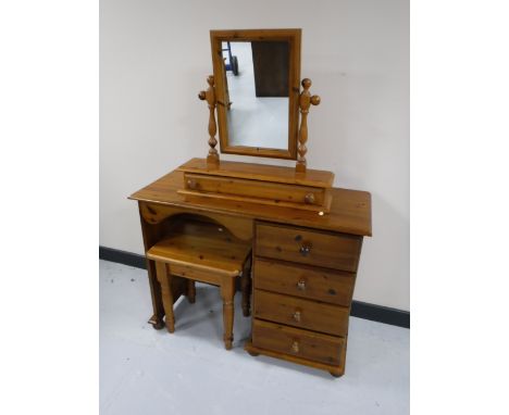 A pine dressing table fitted four drawers with mirror and stool 