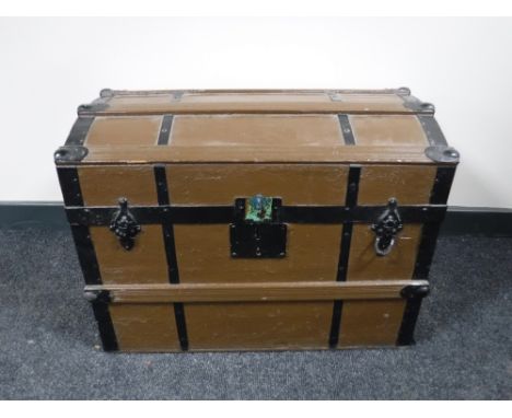 A dome topped metal bound shipping trunk