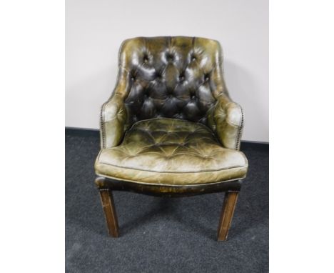 An early 20th century green button leather chesterfield armchair