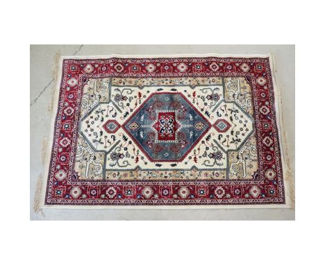 Ivory ground Kashmir carpet with Aztec medallion design, approx 170cm x 115cm