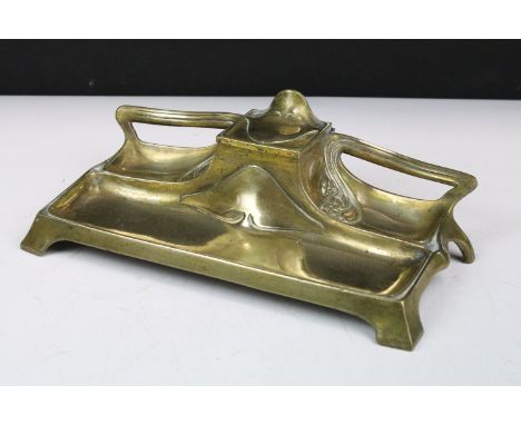 Art Nouveau brass standish or desk stand with central single inkwell, 26cm long