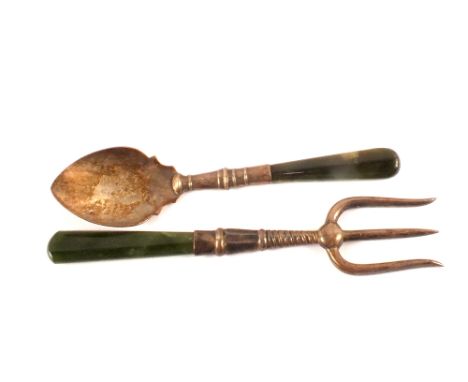 A silver spoon and fork with jade handles