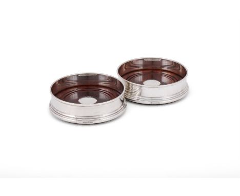 
	
		A PAIR OF SILVER COASTERS
		W. I. BROADWAY &amp; CO., BIRMINGHAM 2004
		13cm (5 1/4in) diameter
		With turned wooden bas
