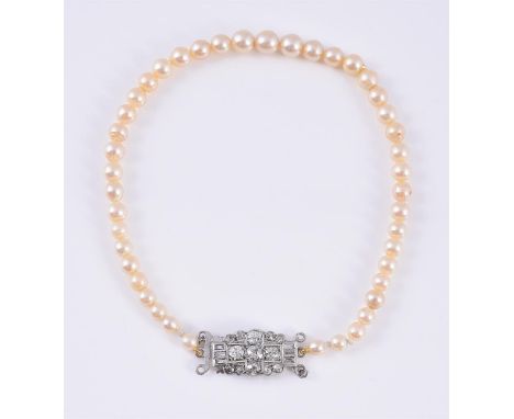
	
		A MID 20TH CENTURY DIAMOND CLASP WITH CULTURED PEARLS 
		The lobed clasp set with old European cut and baguette cut diam