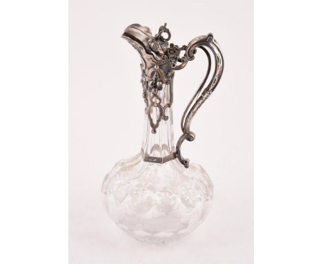 
	
		A VICTORIAN SILVER MOUNTED CUT GLASS CLARET JUG
		JAMES CHARLES EDINGTON, LONDON 1857
		With a C-scroll finial and a scr