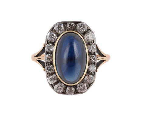 
	
		A SAPPHIRE AND DIAMOND PANEL CLUSTER RING 
		The central sugarloaf cabochon sapphire within a collet setting to a surrou