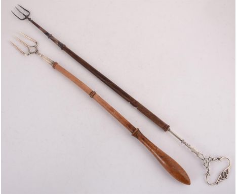 
	
		AN EDWARDIAN SILVER TOASTING FORK
		WILLIAM AITKEN, BIRMINGHAM 1906
		With a turned wooden handle
		58cm (22 3/4in) long