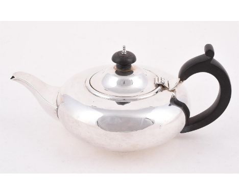 
	
		AN EDWARDIAN SILVER CIRCULAR COMPRESSED TEA POT
		GOLDSMITHS &amp; SILVERSMITHS CO. LTD., LONDON 1905
		With a wooden do