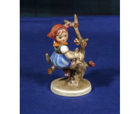 A small Goebel figure of a girl sitting in a tree 