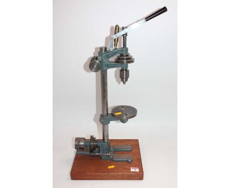 A hand-operated belt-driven pillar drill, raised on wooden display plinth, vendor states scratch built, height 56cm