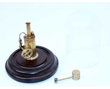 A miniature kit built model of a spirit fired single cylinder vertical steam engine, height 8cm, and housed in a glass displa