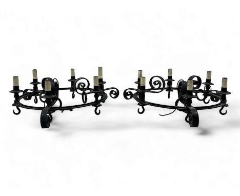 Pair of mid-20th century wrought iron six-light chandeliers, each with a circular frame with scrolled arms, faux candle sleev