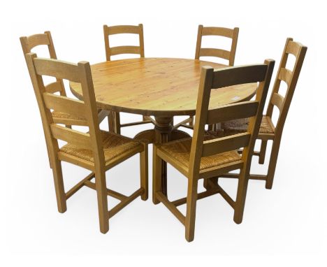 Waxed pine dining table, circular plank top over turned pedestal base with four reeded supports; together with six ladder bac