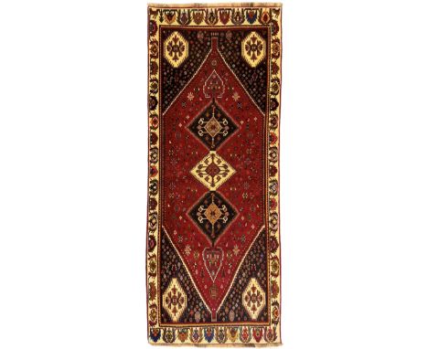 South West Persian Qashqai red ground runner, the crimson field decorated with three connected lozenges, surrounded by small 