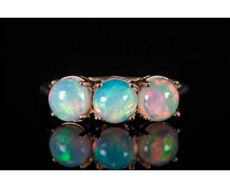 Opal Three Stone Ring, three round cut cabochon opals, with an excellent display of colours, each of 1ct, in a row across the