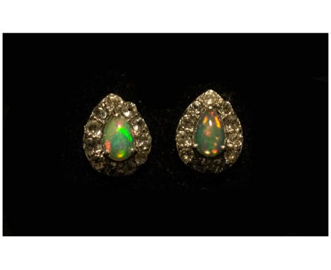 Opal and White Topaz Pair of Stud Earrings, each earring comprising a pear cut opal cabochon of .5cts with a frame of round c