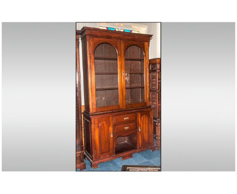 An Edwardian Mahogany Glazed Book Case on Dog Kennel Base. With 2 Shaped Glazed Doors Above, with a Moulded Cornice with Thre