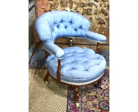 A Victorian walnut framed button blue silk upholstered open elbow chair, raised on white ceramic castors