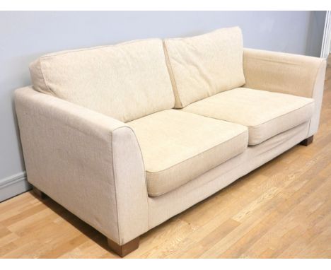 A modern three seater sofa, upholstered in a beige chenille fabric, with reversible cushions.  210cm x 96cm x 95cm.Like new c