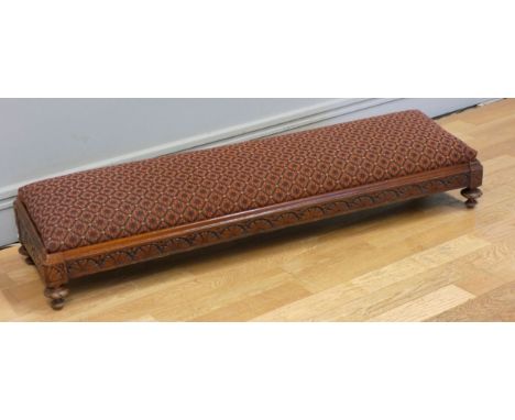 A mahogany framed upholstered padded foot rest, with carved decoration on button feet. 10cm x 29cm x 20cm 