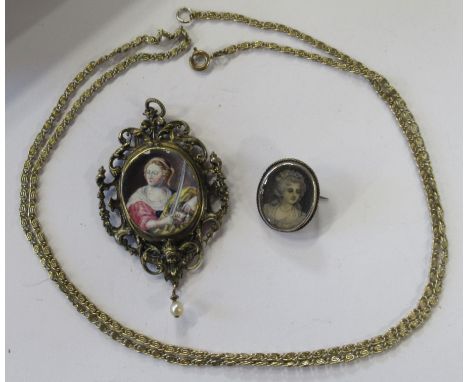 A gilt metal pendant, the centre with enamel portrait, with scroll frame, the reverse with glazed locket and script, height 3