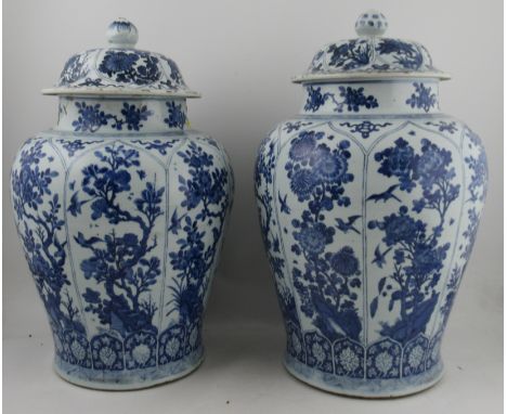 A matched pair of Kangxi period blue and white baluster vases and covers, each decorated with segmented panels and prums loct